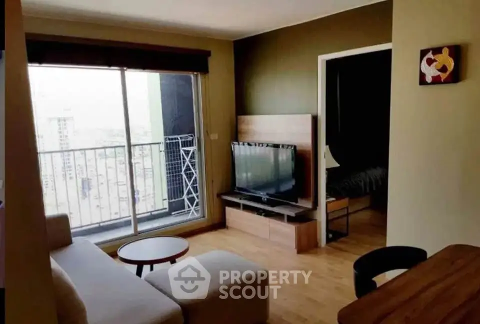 Modern living room with balcony view in high-rise apartment, featuring sleek furniture and natural light.