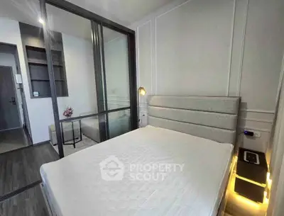 Modern bedroom with sleek design and glass partition in a stylish apartment.