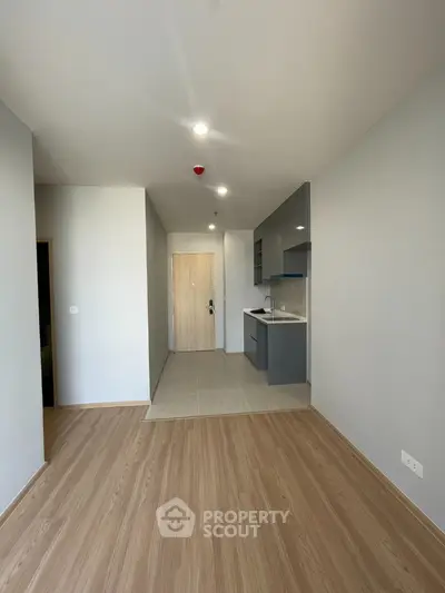 Modern minimalist apartment interior with open kitchen layout and wooden flooring