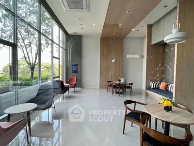 Modern and spacious common area with large windows and stylish seating, perfect for relaxation and socializing.