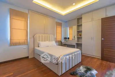 Spacious bedroom with modern design and ample storage in a cozy home.
