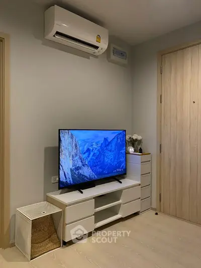 Modern living room with sleek TV setup and air conditioning unit.