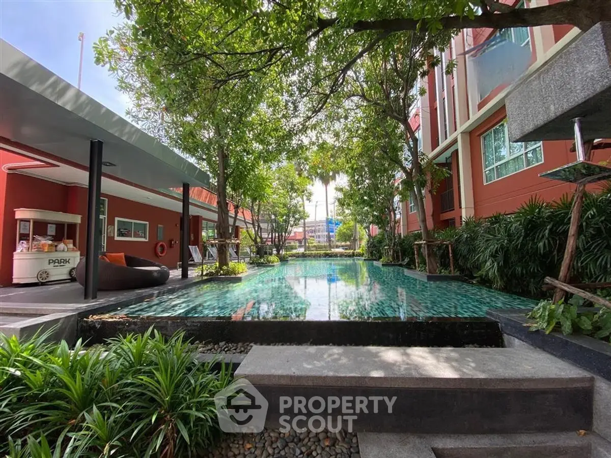 Luxurious residential pool area with lush greenery and modern architecture, perfect for relaxation and leisure.