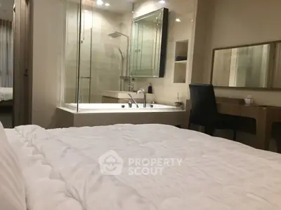 Luxurious bedroom with ensuite bathroom featuring a modern bathtub and elegant decor.