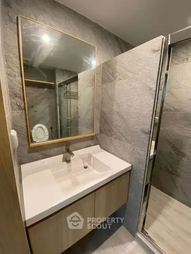 Modern bathroom with sleek vanity and large mirror in a stylish apartment.