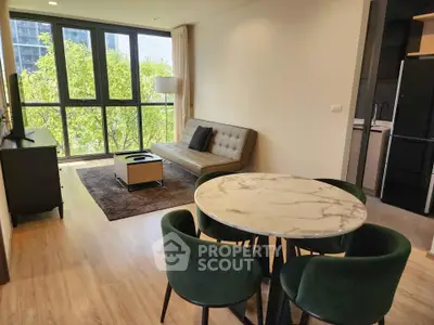 Modern living room with large windows and stylish furniture in a bright apartment.
