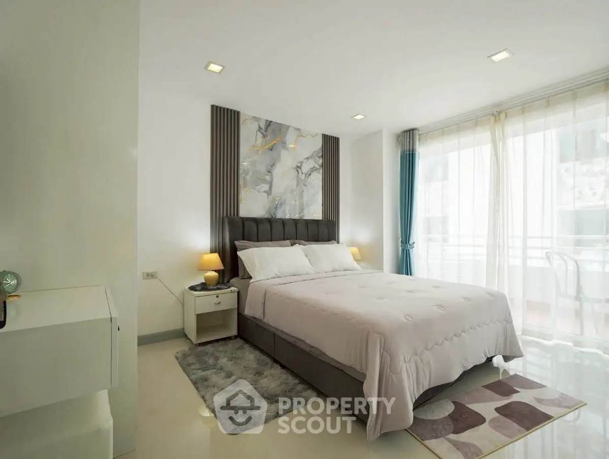 Elegant bedroom with modern decor and large windows offering natural light