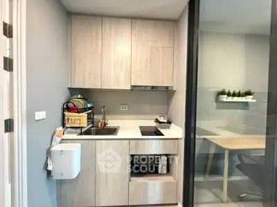 Modern compact kitchen with sleek cabinetry and integrated appliances in a stylish apartment.