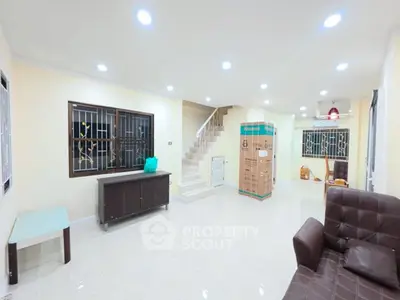 Spacious living room with modern lighting and staircase