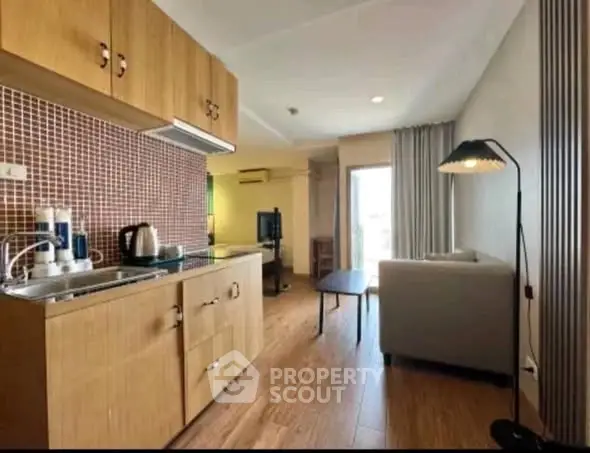 Modern open-layout living room with kitchenette and cozy seating area.