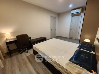 Modern bedroom with minimalist design featuring a comfortable bed and a work desk, ideal for relaxation and productivity.