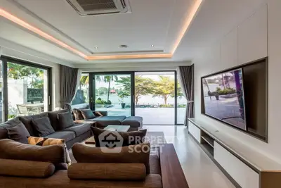 Luxurious living room with modern design and stunning poolside view, perfect for relaxation and entertainment.