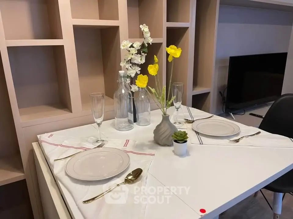 Elegant dining setup in modern living room with stylish shelving and TV