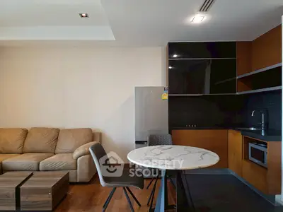 Modern living room with sleek kitchen and cozy seating area