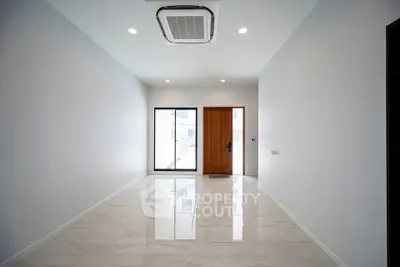 Spacious modern living room with glossy tile flooring and large window for natural light.