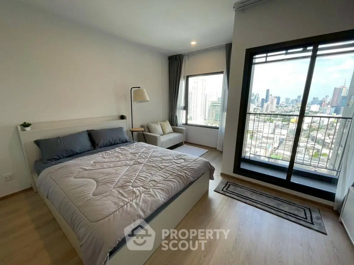 Spacious bedroom with city view and cozy seating area