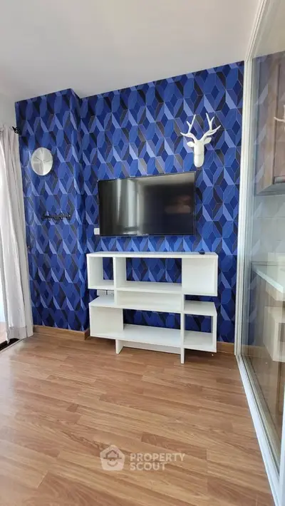 Modern living room with stylish blue geometric wallpaper and mounted TV