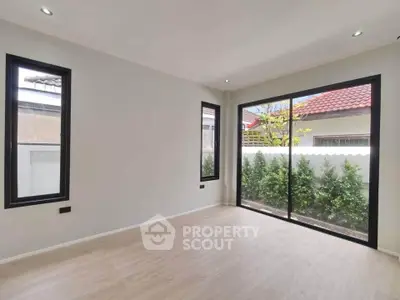 Spacious room with large windows and garden view, perfect for natural light lovers.