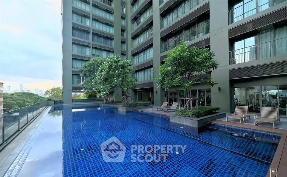 Luxurious condominium with stunning pool and lush greenery in a modern urban setting.