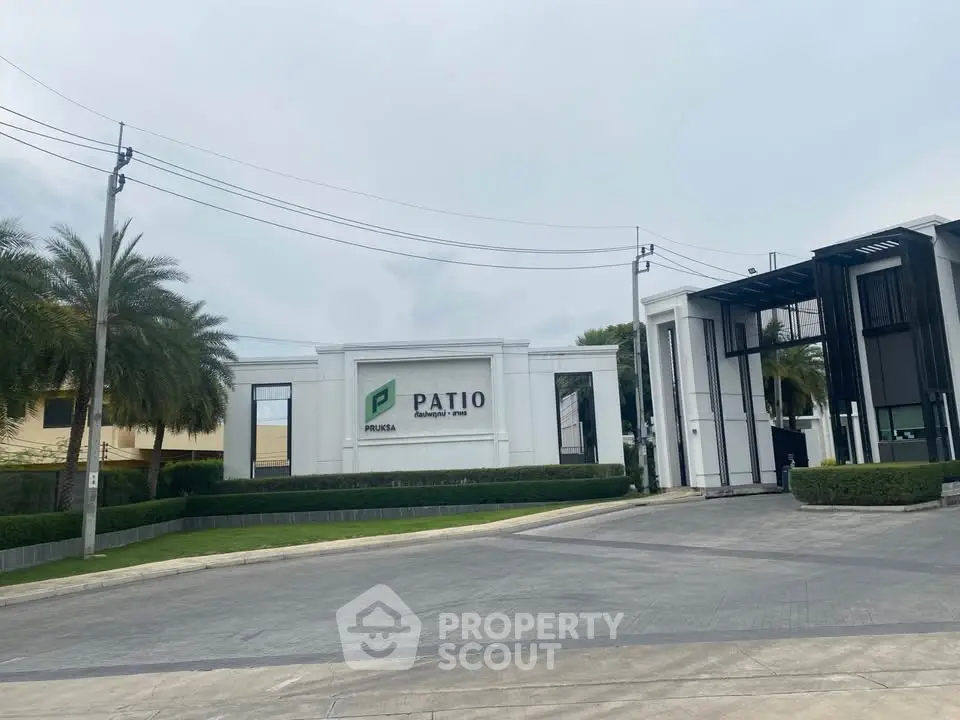 Modern residential entrance with sleek design and lush landscaping at Patio Pruksa.