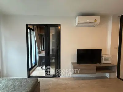 Modern living room with air conditioning and TV, featuring a sleek design and neutral tones.