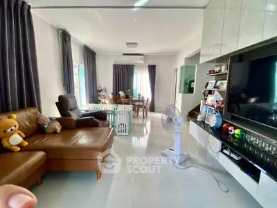 Spacious living room with modern decor and large TV, perfect for family gatherings.