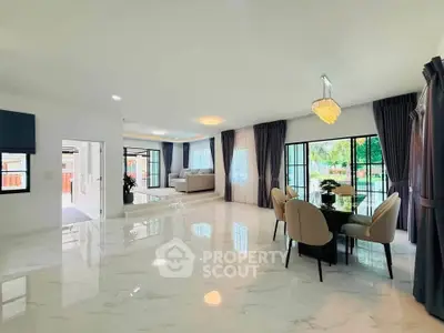 Spacious modern living room with elegant dining area and large windows offering garden views.