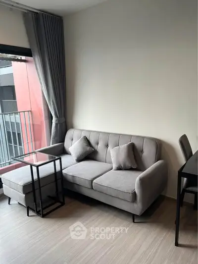 Modern living room with stylish gray sofa and sleek furniture, perfect for urban living.