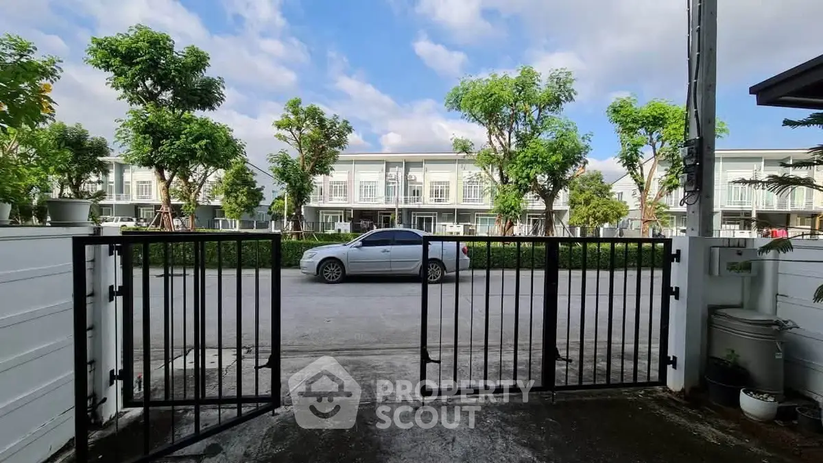 Charming residential street view with modern townhouses and lush greenery.