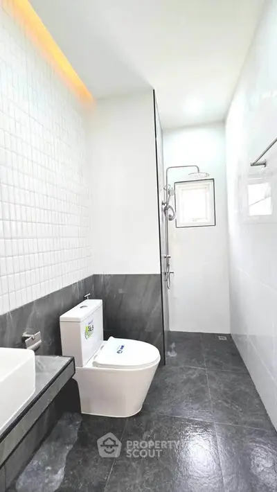 Modern bathroom with sleek design and high-quality fixtures, featuring a stylish toilet and shower area.
