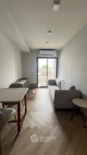 Modern living room with sleek furniture and balcony view in a stylish apartment.