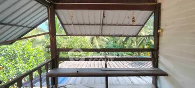 Charming rustic balcony with lush green views and wooden seating area.