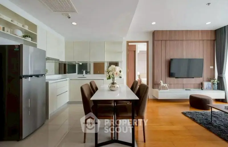 Modern open-layout kitchen and living room with sleek design and stylish furniture.
