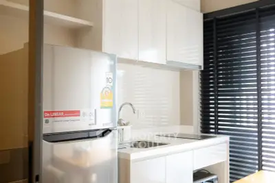 Modern kitchen with sleek cabinets and stainless steel fridge in bright apartment