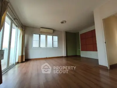 Spacious empty living room with wooden flooring and large windows
