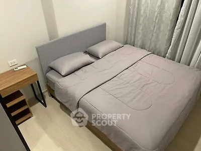 Cozy bedroom with modern design featuring a comfortable bed and stylish side table, perfect for relaxation.