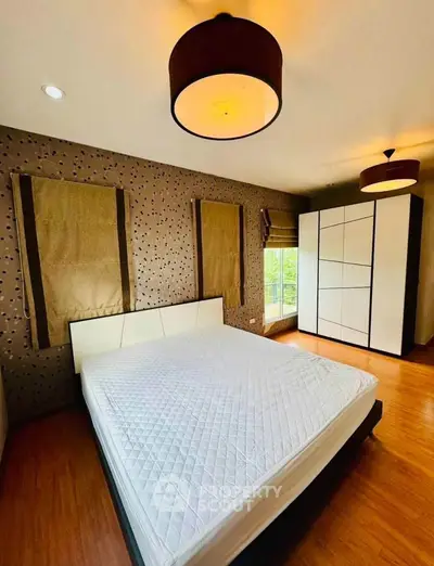 Spacious modern bedroom with stylish lighting and large wardrobe