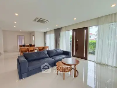 Spacious modern living room with large windows and elegant furniture in a luxury home.