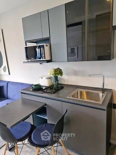 Modern compact kitchen with sleek cabinets and dining area in stylish apartment