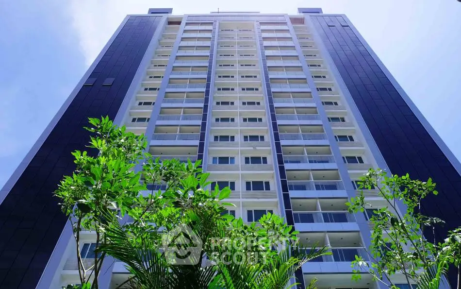 Modern high-rise building with sleek design and lush greenery, perfect for urban living.