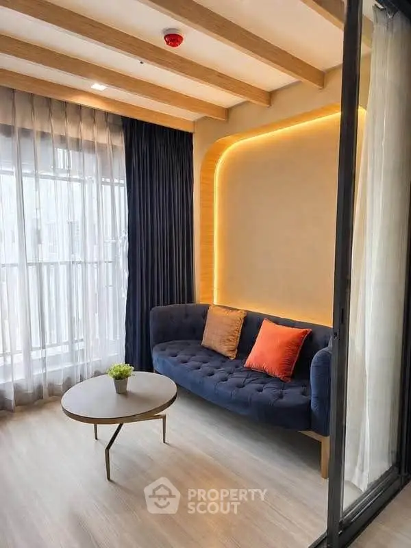 Stylish living room with modern sofa, elegant lighting, and large window for natural light.