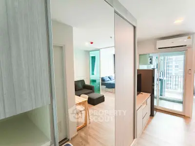 Modern apartment interior with open living area and balcony access, featuring sleek design and natural light.