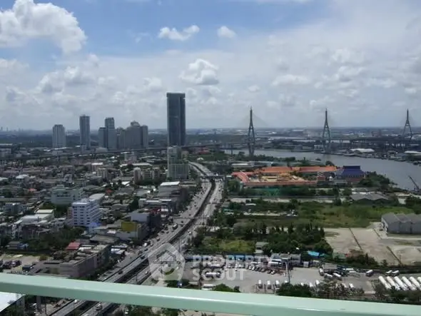 Stunning cityscape view from a high-rise balcony overlooking urban skyline and river.