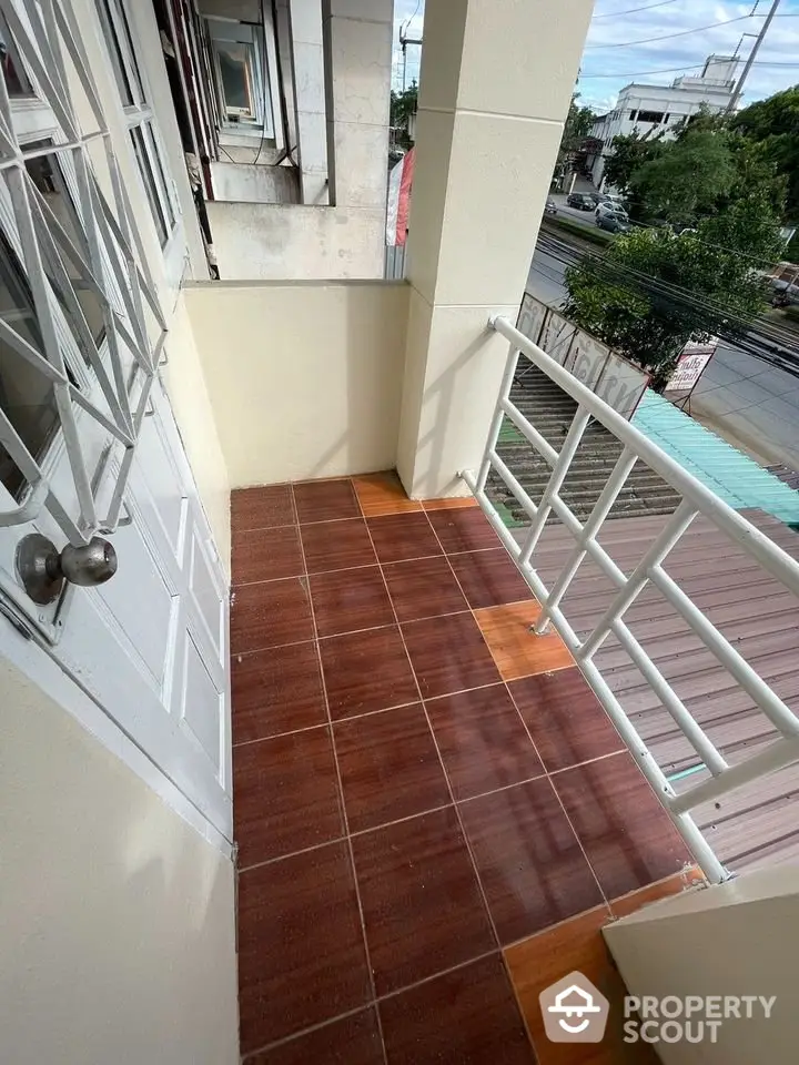 Charming balcony with tiled flooring and street view, perfect for relaxation and enjoying the outdoors.