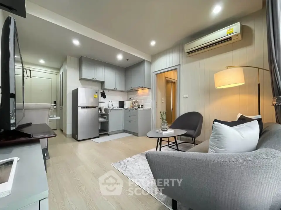 Modern open-plan living room with kitchen, featuring sleek furniture and ambient lighting.