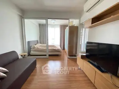 Modern studio apartment with wooden flooring and glass partitioned bedroom