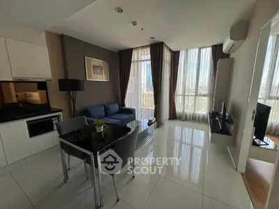 Modern living room with sleek furniture and large windows offering city views.