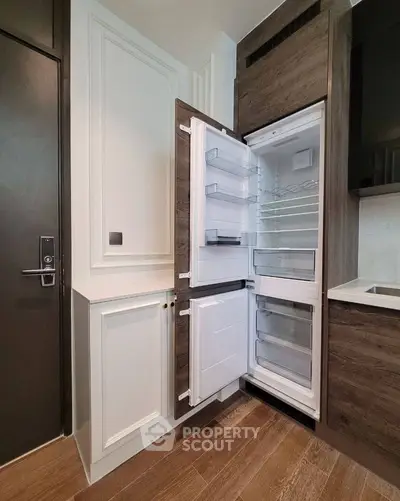 Modern kitchen with built-in fridge and sleek cabinetry in a stylish apartment.