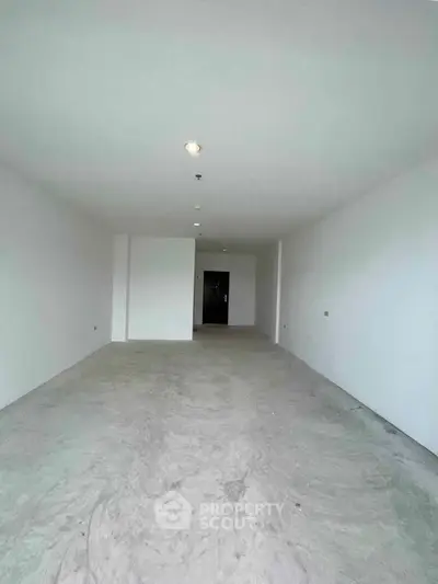 Spacious empty room with white walls and concrete floor, ideal for customization.