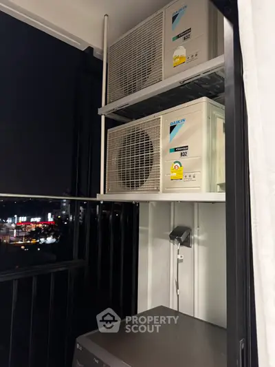 Modern balcony with air conditioning units and city night view, perfect for urban living.